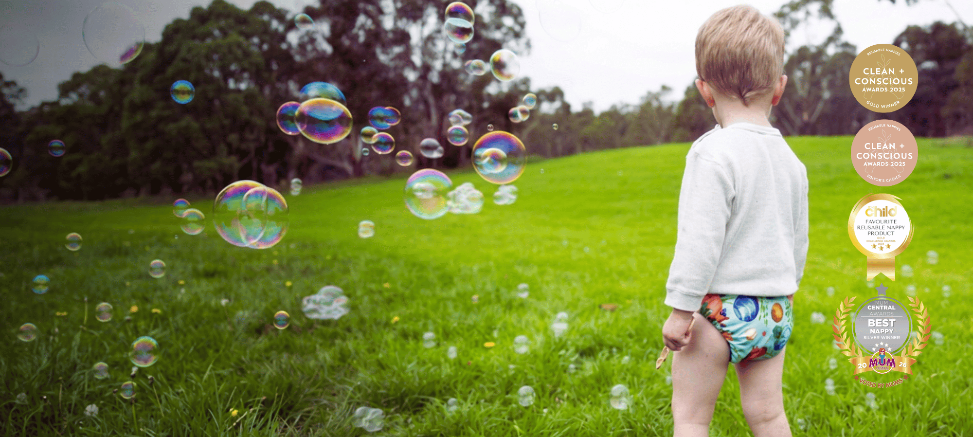 Child playing with bubbles in a grassy field
